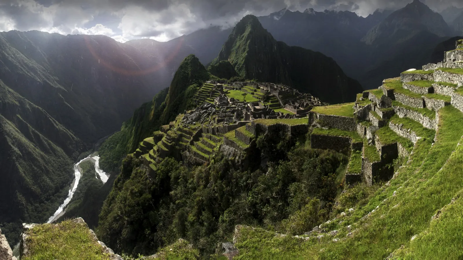 Machu Picchu citadel above the Urubamba river canyon under dramatic storm light